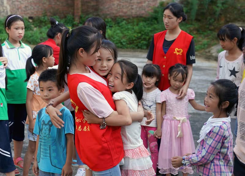 7月13日，在廣西柳州市融安縣泗頂鎮壽局村，志愿者和孩子們做游戲。